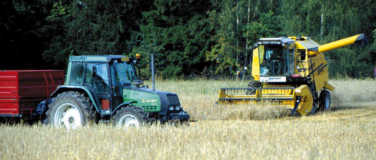 Traktori ja puimuri pellolla.
