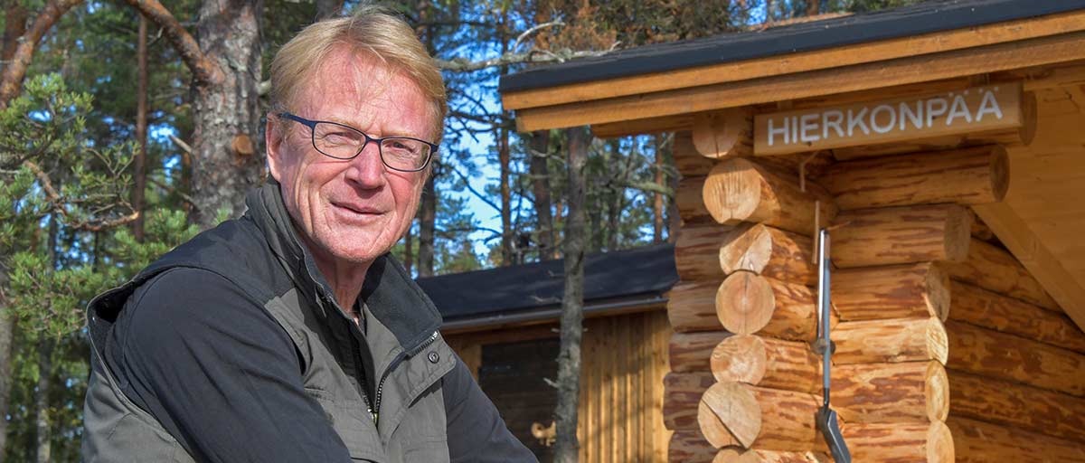 Kunnanjohtaja Harri Hiitiö istuu Hierkonpään retkeilypaikassa